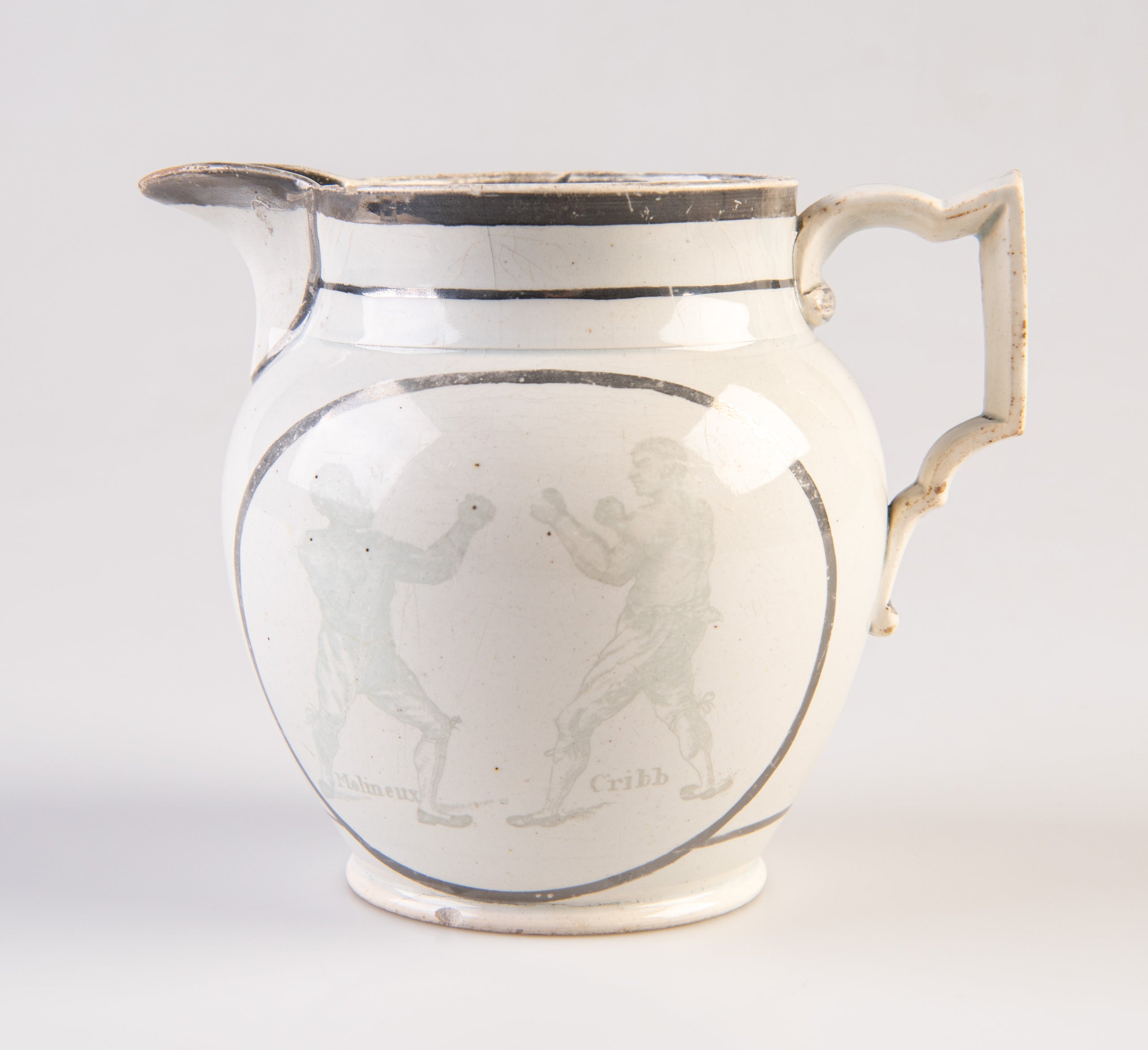 [Pearlware jug decorated with transfer image of Tom Molineux and Tom Cribb facing each other in a boxing match, a verse to the other side.]