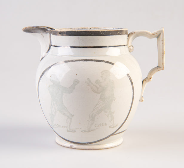[Pearlware jug decorated with transfer image of Tom Molineux and Tom Cribb facing each other in a boxing match, a verse to the other side.]