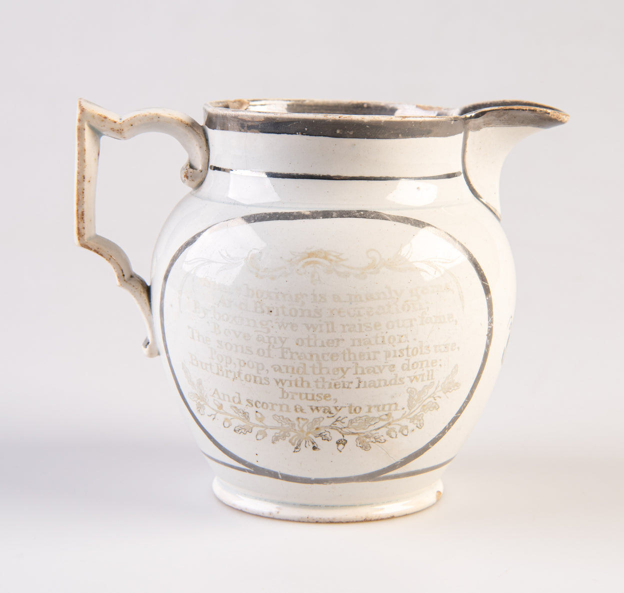 [Pearlware jug decorated with transfer image of Tom Molineux and Tom Cribb facing each other in a boxing match, a verse to the other side.]